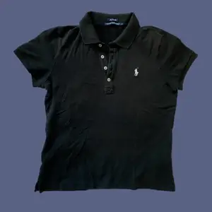 En svart polo- t-shirt från Ralph Lauren med krage och knapp detaljer. I super fin material. 