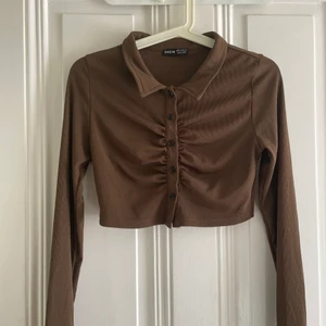 Brun Topp - Hej säljer en super fin tröja från SHEIN. Älskar den men kommer tyvärr inte till användning! Svarta knappar som går att knäppa upp om man vill! Använd fåtal gånger som ny! 