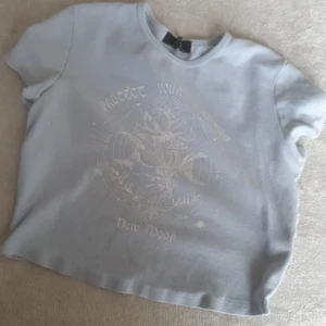 Croptop - Är en baby blå croped T-shirt med vita detaljer 