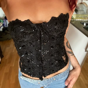 Paljettig korsett - Otrolig korsett hittat på second hand, transparent på sidorna och dragkedja och krok med hake fram. Se baksidan på sista bilden.  Fyller inte upp kuporna helt utan skulle passa bättre till en b-kupa typ, otroligt tight på mig. 