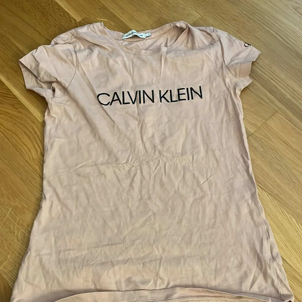 En rosa Calvin Klein t-shirt. Fattar inte riktigt storleken de står 14 på den. Men jag har storlek s på tröjor den passar mig men är lite tajt.Köpte den från zalando ny minns inte riktigt vad den kosta men säljer den billigare än vad jag köpte den för.😊. T-shirts.