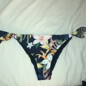 Bikiniunderdel - Blommig bikiniunderdel från HM i storlek 36 i ”brazilian” modell. Helt oanvänd och skyddsplast sitter kvar. 