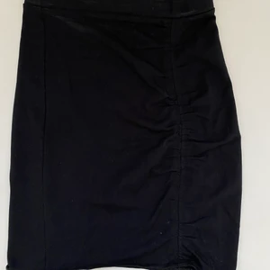 Svart tajt kjol från H&M - Svart tajt kjol med rynkad detalj på ena sidan