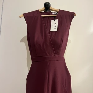 NA-KD Jumpsuit - Helt ny!! Mörkröd jumpsuit med fickor på var sin sida. 