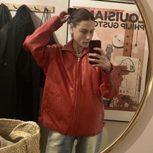 Röd skinnjacka - Ballaste skinnjackan i perfekt skick. Ganska mjuk i skinnet så väldigt skön. Har sidofickor och stängs med dragkedja. Jag är Xs-s så uppskattar den passar upp till m. 