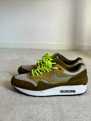 Nike air Max 1 - OlivGröna och gråa, med egna neongröna snören. Orginalsnöre (gråa) finns kvar.  Sparsamt använda, cond: 7/10