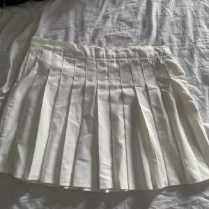 Jättesnygg vit veckad kjol från bikbok. Endast använd en gång och köpt för 300 kr. Man knäpper den på sidan med dragkedja och knapp. Frakt tillkommer