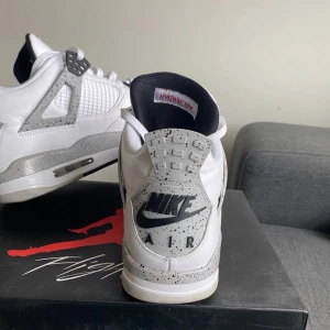 Skor - Jordan 4 white cement black, skick 8,5/10, säljer eftersom jag snabbt tröttnar på skor och är sugen på nya, höra av er vid fler frågor, storlek 46.