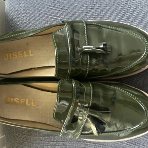 Loafers gröna - Skott snygga loungers som är nästan helt oanvända Från märket DISELL. Fina detaljer en glansig härlig grön färg. Storlek 36 men skulle luta mer åt 37 för de är lite för störa för mig som har 36