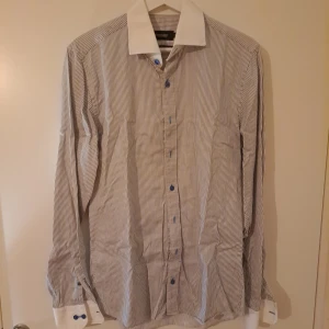 Dressmann skjorta  - Skjorta från Dressmann premium collection. Blå/grå rad, stl M 39/40