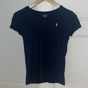 Ralph Lauren t-shirt  - Mörkblå Ralph lauren t-shirt med en väldigt ljusrosa häst. Barnstolek XL/16. Nyskick.  100 kr. 