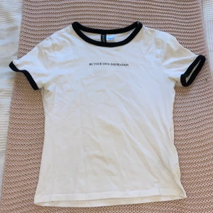 Supersöt topp - En jättefin topp som är från HM. Den har svarta kanter vid ärmarna och vid kragen och har även svart text på framsidan. Baksidan är endast vit. Storlek XS. Pris kan diskuteras!