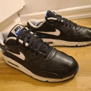 Nike AirMax90 - Nike Air Max 90 som är i bra skick.  Svart skinn med vit och blå sula.  