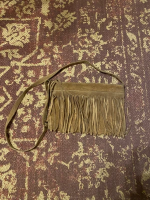 Brandy Melville väska  - Brandy Melville väska   Brun mocka med fransar (vet inte om det är äkta mocka eller fusk)  