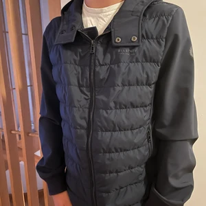 Belstaff vårjacka- herr - Belstaf herr jacka, perfekt stora delar av året. Mycket gott skick, marinblå. Fordrad mage och rygg, lätt vattenavvisande ärmar. Luva. Strl 36 herr