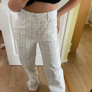 Vita/rutiga byxor från ASOS  - Vita jeans/byxor från ASOS med tunt grönt och lila rutmönster. Byxorna är i storlek 34 och för långa på mig som är ca 162 cm lång. Aldrig använda! Köparen står för eventuell frakt.