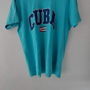 Blå tröja med trycket Cuba på samt flaggan. Köpt secondhand hand därefter oanvänd.