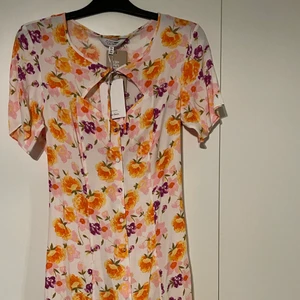 Klänning - Helt oanvända klänning, prislappen sitter kvar, somrig och blommig, säljer den pga att den inte är min stil, köpte den för 800kr men säljer för 100kr, storlek 40 men är liten så passar även som en 38