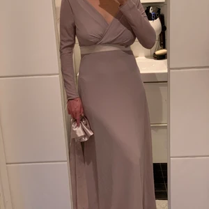 Balklänning - Jättefin och bekväm grå/lila balklänning/brudtärneklänning. Använd en gång, som ny! Faller fint på kroppen. Finns avtagbar rosett på ryggen