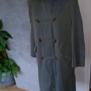 Skräddarsydd Duffel - Bomullstwill som changcerar i grönt och blått. Kort ärm/50-tal.Rutigt bomulls goder och bruna läder knappar. 