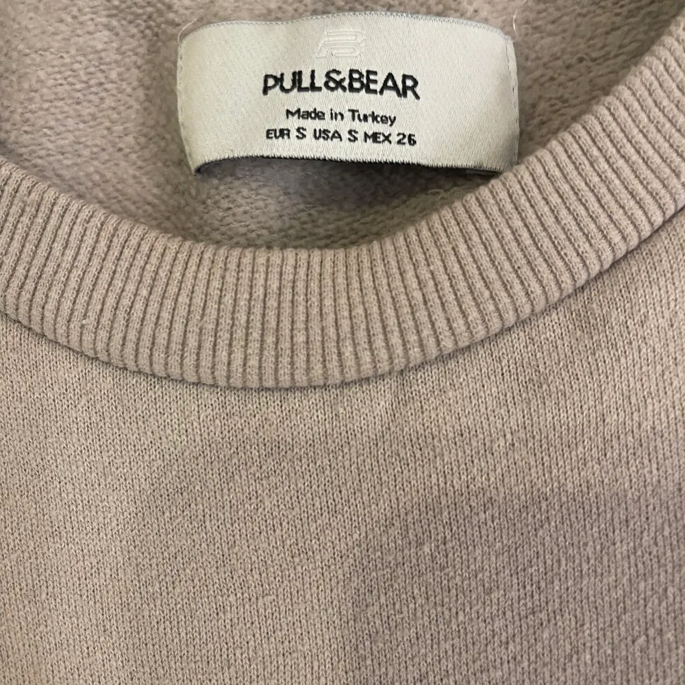 En jättefin beige hoodie från PULL&BEAR som knappast är använd den är i storlek xs och har resårband längst ner . Tröjor & Koftor.