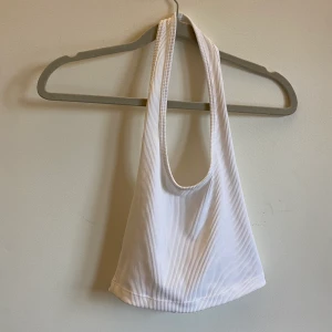 Vitt linne med öppen rygg - Linne med öppen rygg köpt på H&M. Super fint dock aldrig använt på grund av att jag har andra likande tröjor som jag använder mer. Säljer på grund av att tröjan också är för liten för mig. Tröjan är smått genomskinligt om du inte har en bh under.