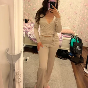 Beige set, helt nytt skick. Använd Max 1-2 gånger.  - Beige polyester set från BikBok, använd Max 1-2 gånger. Väldigt skönt material, har band som sitter fast i tröjan.  Är i helt nytt skick. Byxan är storlek S och tröjan i storlek M (sitter som S). Köptes för 500kr. 