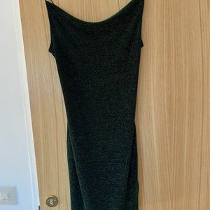 Festklänning  - Den perfekta festklänningen. Svart grönglittrig tight klänning.