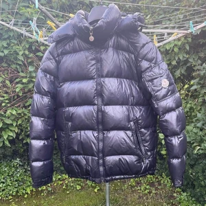 Moncler Maya Navy - Asfet Maya jacka till vintern. Size 4 vilket motsvarar cirka L, men passar mig som har m i tröjor. Mycket bra skick, dock en äldre modell så qr finns ej. Har fått jackan legitcheckad i monclergruppen på facebook