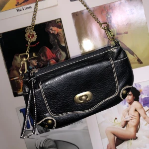 Svart handväska - Charmig liten handväska från märket Duffy. 1 fack med dragkedja på insidan samt att man kan öppna facket på framsidan! 