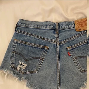 LEVIS SHORTS - LEVIS shorts köpta på second hand. Lite svårt att se storleken men tror det är W30 men passar mig med S och kan förmodligen passa någon som bär strl M. Fransar nertil och det är slitningar på båda bakfickorna ( kan skicka fler bilder på det). Second hand 
