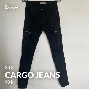 Cargo jeans svarta S - Cargo jeans i storlek S  Oanvända, legat i en garderob.  Fickor bak, sidan av benen och fram.   Storlek S   Kan skickas. Frakt tillkommer med 66kr spårbart!