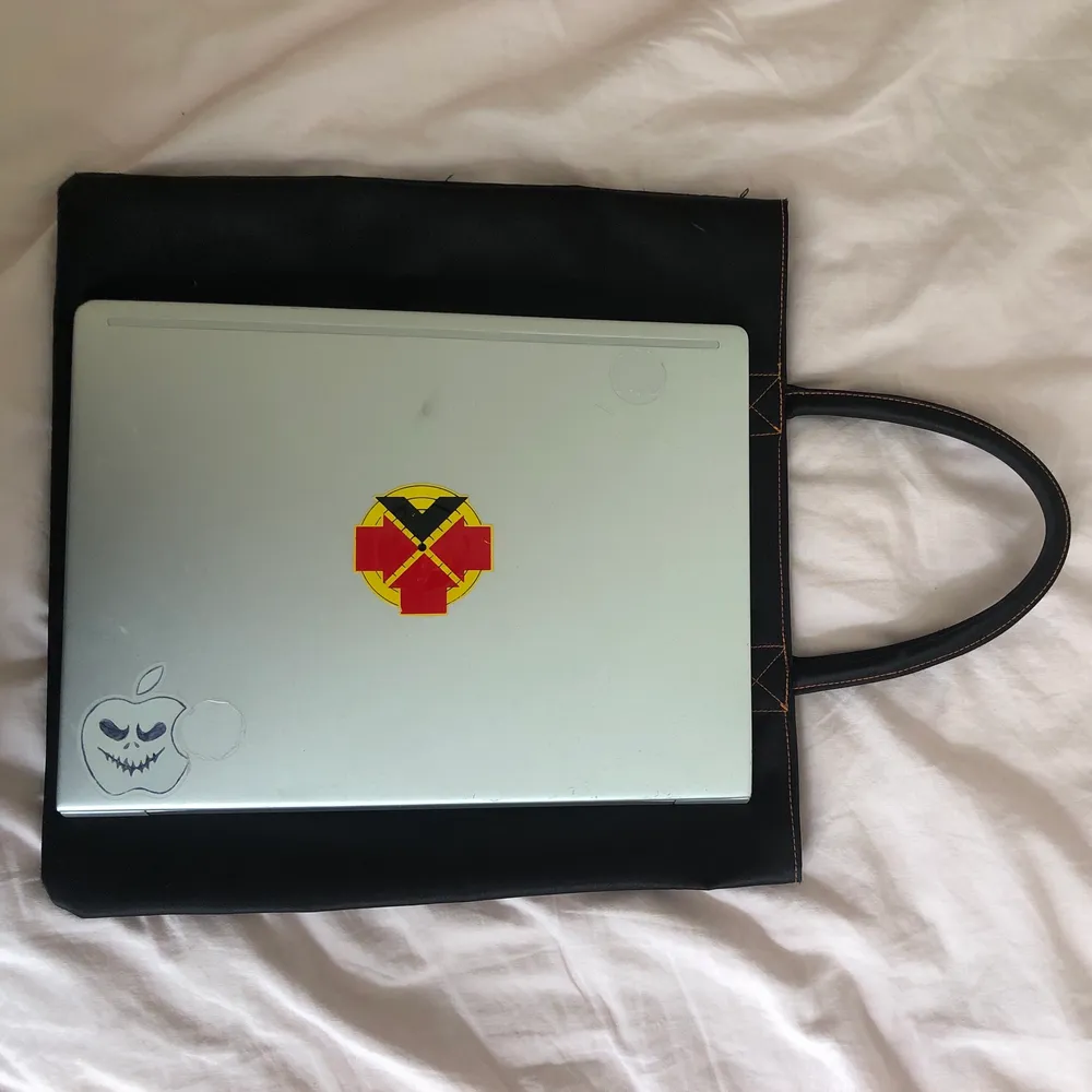 En väska i svart glansigt tyg med oranga sömmar från lancome. Perfekt storlek för datorn, har ett innerfack och handtagen är hårda och formade. Skriv för fler bilder eller vid frågor! . Väskor.