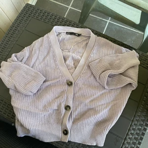 Kofta - Stickad kofta i en jättefin lila färg (bilden visar dock inte färgen riktigt). Snålt använd. Frakt tillkommer och köparen står för frakten. 