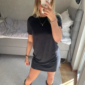 T-shirt klänning  - Säljer denna coola T-shirt klänning pga att den inte kommit till användning. Den är köpt på Myrorna, liten defekt på höger arm då stygn lossnat som viker upp ärmen, se bild. Den är aldrig använd och prislappen sitter kvar. Köparen står för frakt. 