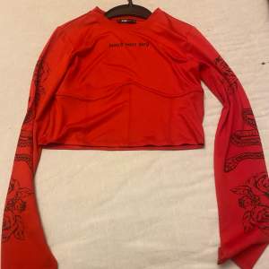 En röd tröja med text. Nästan helt ny
