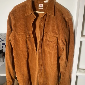 Manchesterskjorta från Levis - Orange överskjorta från Levis i manchestertyg. I gott skick. Säljes då jag ej använder den längre. 