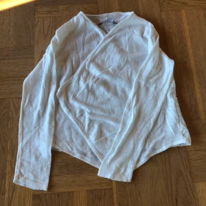 Kofta - En vit jättefin kofta med spets på ryggen i stl 128.