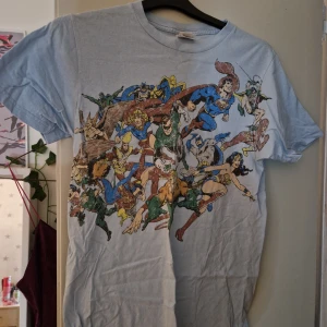 Tshirt - Ljusblå tshirt med tryck på i storlek M. Trycket är slitet, osäker om det är designen eller bara slitet.