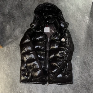 Moncler Maya Down - Storlek 3 ≈ M Knappt använd, skrapa på vänstra fickans knapp på armen, och cartoonen är lite bränd av fiverkerier..  Svart 
