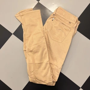 G-star jeans - Gstar beiga jeans i mjukt skönt stretchigt bomullstyg. W27 L30. Mäter 37 cm rakt över. Använda 2 ggr. Low cut. Stuprör.