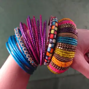 Stela armband i fina färger och former. Hela, fina och har alla sina stenar och pärlor kvar! Det bredaste i indisk stil är ca 2,5 cm brett och alla har en inneromkrets på ca 6,5 cm. 30kr per set (alla rosa, alla blåa etc) eller bud på allt.