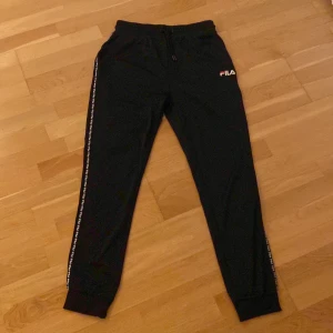 Fila byxor  - Dessa byxor har blivit använda 4-5 gånger, deras skick är som helt nya. Byxorna är gjorda av 100% polyester och har därmed en silkeslenare känsla än vad bomull har. 