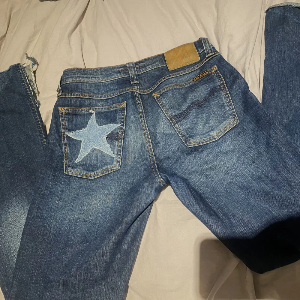 Inte säkert att jag säljer!  Skitsnygga Nudie jeans som är Lågmidjade bootcut med slit nertill med en påsydd stjärna på rumpan! Är 160 och de är lite för långa på mig. Köpte  secondhand via ett företag❤️midjemåttet är 82cm . Jeans & Byxor.