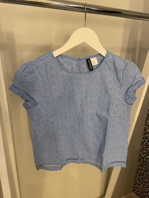 Blå blus - Blå blus/topp från HM i storlek 32, fin i ryggen då det är knappar. Aldrig använd så nyskick!✨Köparen står för frakten, kan mötas upp i Kalmar