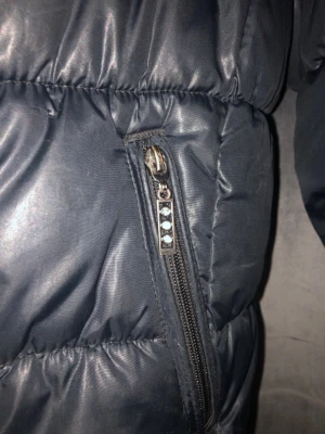 Täckjacka  - Svart täckjacka med silver detaljer.