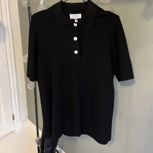 Svart t-shirt  - Svart oversized  t-shirt med knappar och skjortkrage från Other Stories. Använd fåtal gånger och bra skick. Köparen står för frakten🫶🏼