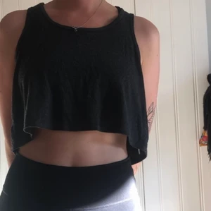 Grå/svart linne  - Ett croptoplinne i grå/svart nyans. Kommer från topshop, haft den länge och varit en favorit! Funkar soft som träningslinne med! 