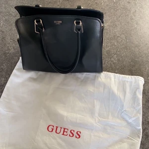 Guess väska  - Säljer en äkta guess svart väska. Knappt använd! Köparen står för frakten!!
