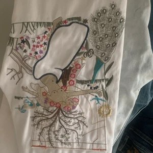 True religion jeans - Ett par vita true religion jeans med ett coolt tryck broderat på rumpan. De är i straight/bootcut modell, jag är ca 163,5cm. Midjemått tvärsöver är 37cm och innerbenslängden 72cm. Bara att höra av sig vid frågor, använd inte köp nu funktionen :)